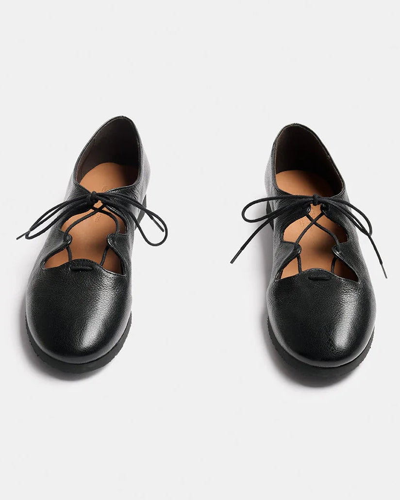 A pair of black leather lace-up shoes with a rounded toe and decorative cutout details, shown from a top-down view on a light gray background.