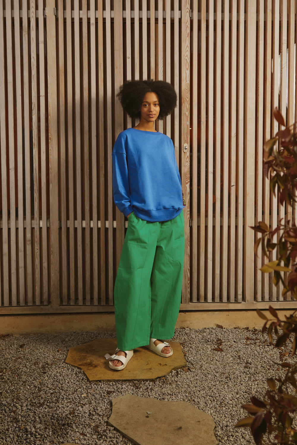 A pair of green cotton workwear style trousers with high elasticated waist and utility style pocket detailing.