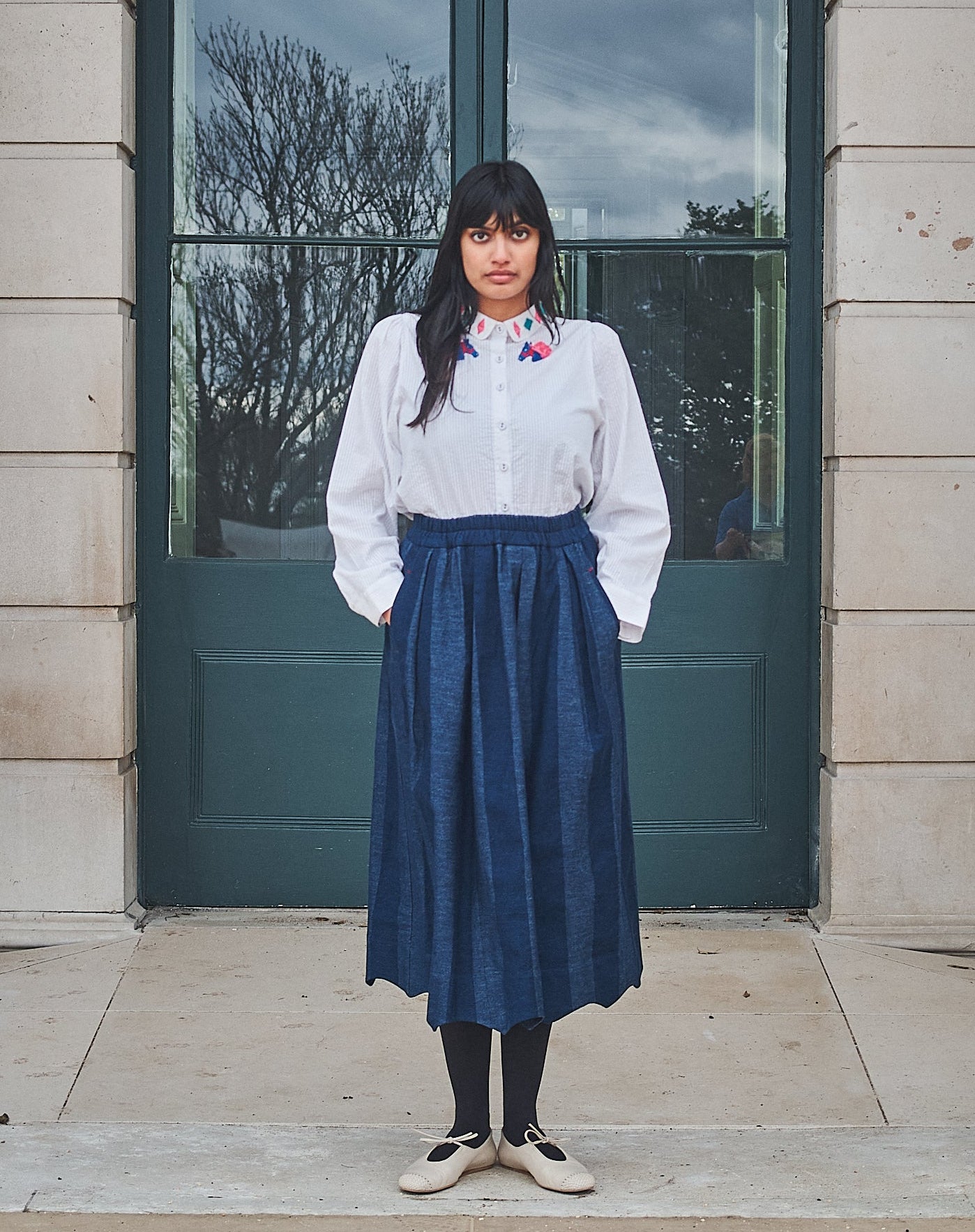 Woman standing in front of a building with columns and large windows