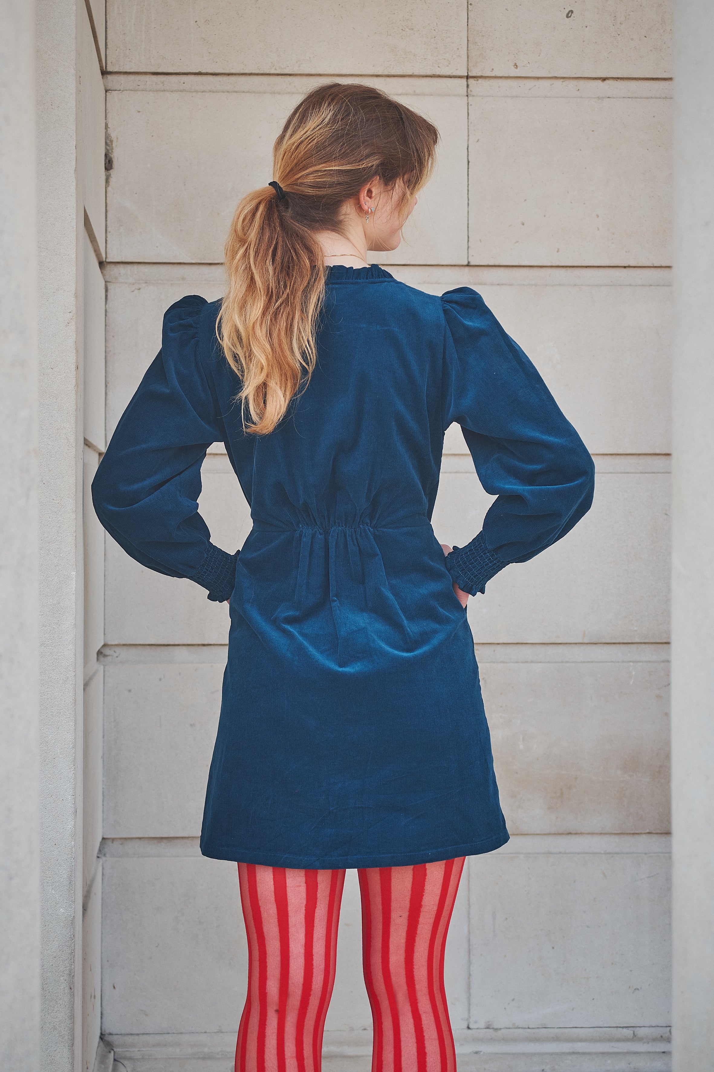 woman wearing a short navy corduroy dress
