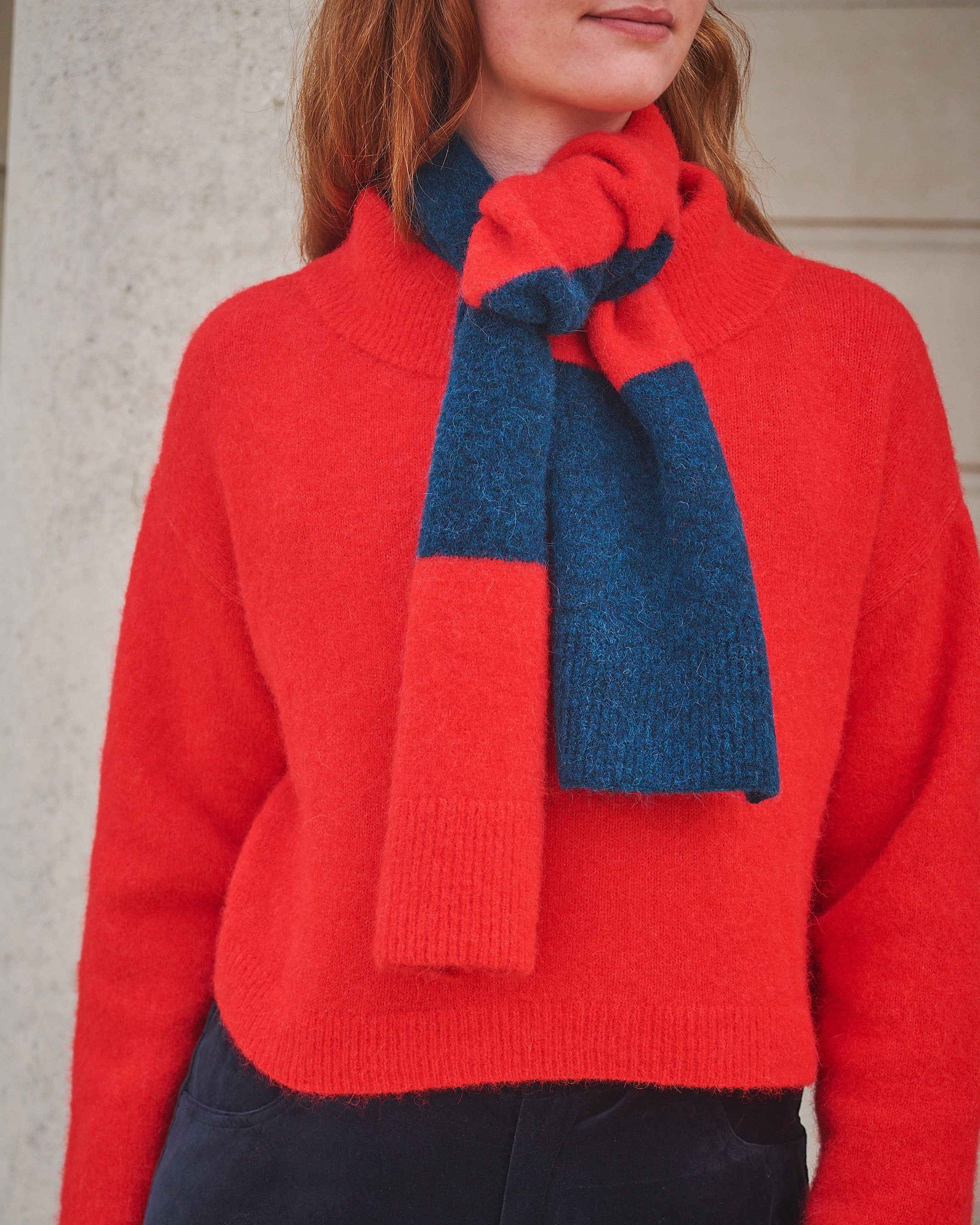 Person wearing a Lowie stripe Red/ Blue scarf