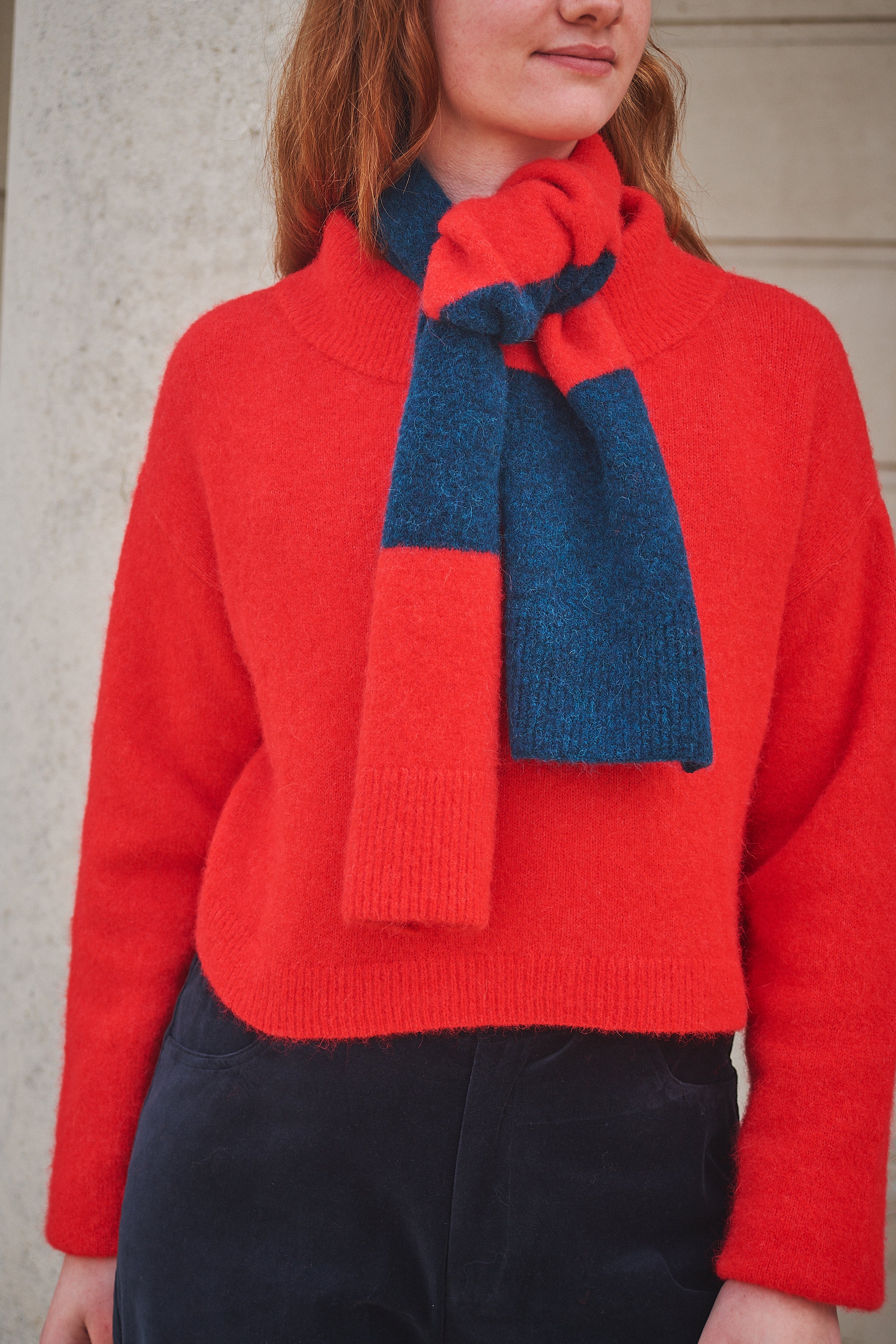 Person wearing a Lowie stripe Red/ Blue scarf