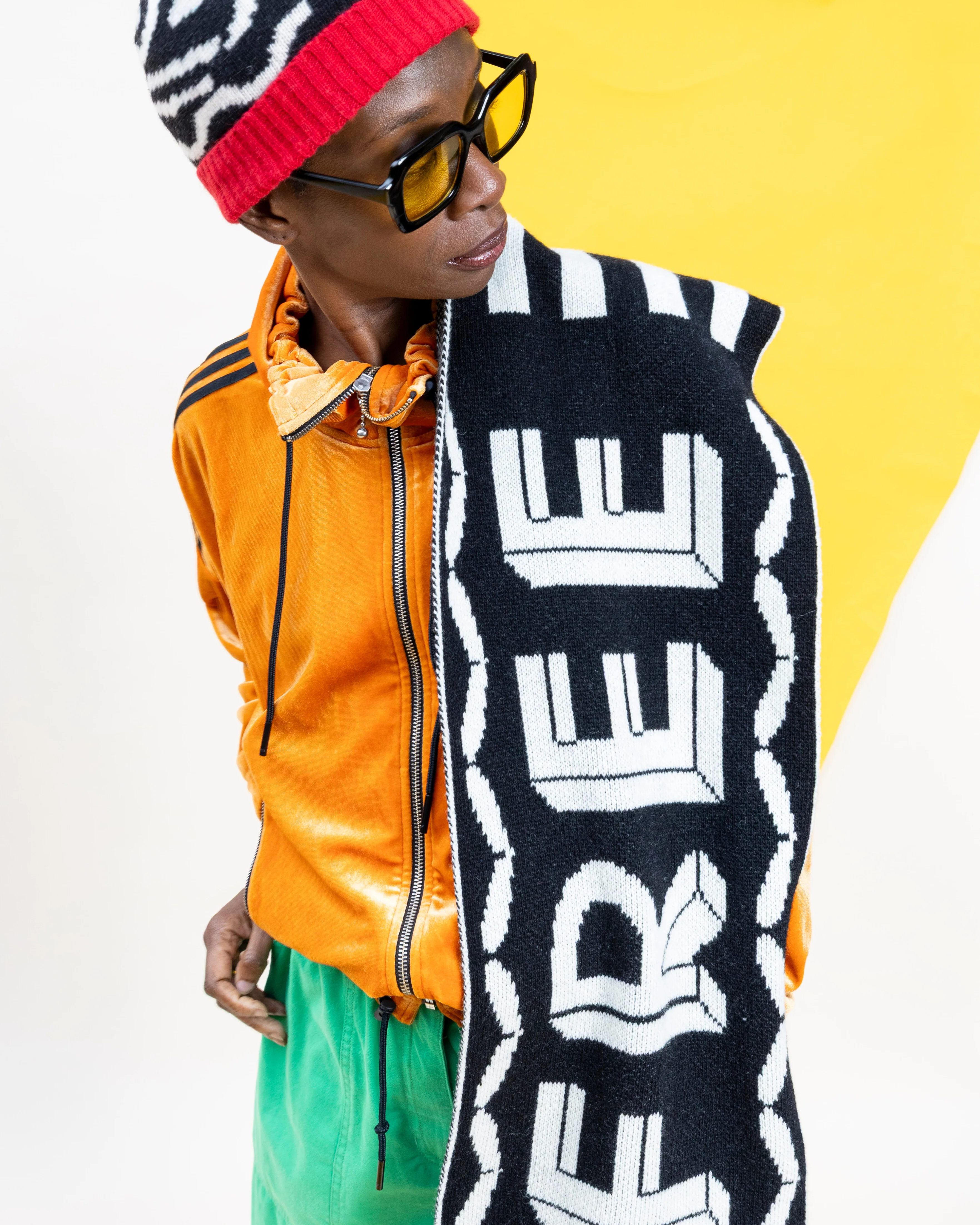 Person wearing a colorful outfit with a 'FREE' scarf against a yellow background