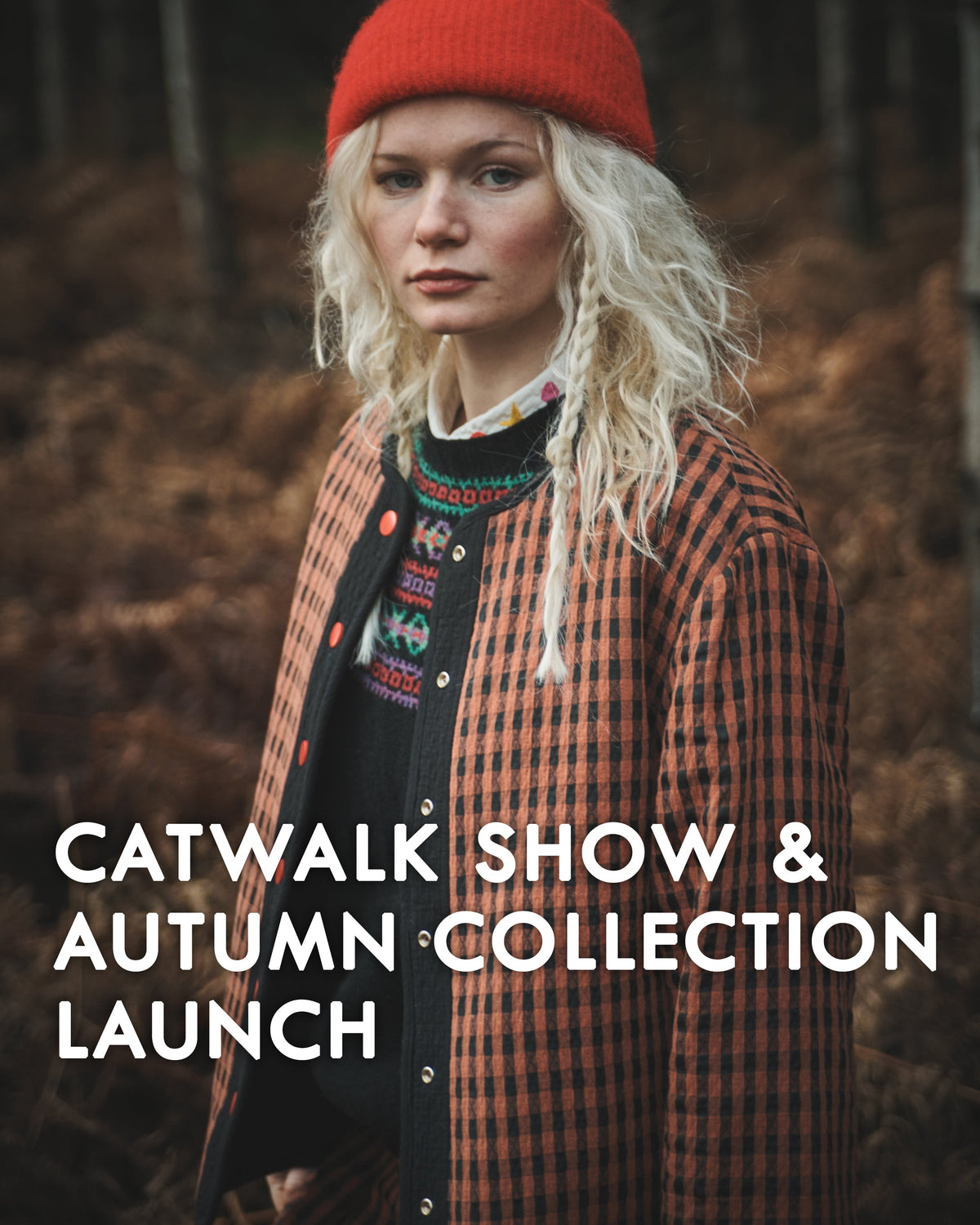 A woman outdoors in a forest setting wearing a bright red knit beanie, a red-and-black plaid button-front jacket, and a patterned sweater. Large white text across the lower portion reads 'CATWALK SHOW & AUTUMN COLLECTION LAUNCH'.