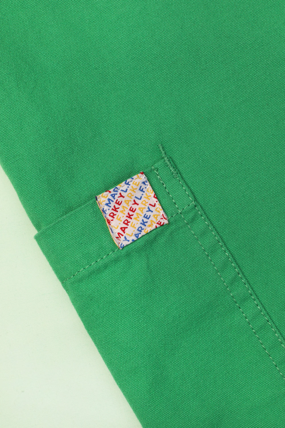 A pair of green cotton workwear style trousers with high elasticated waist and utility style pocket detailing.