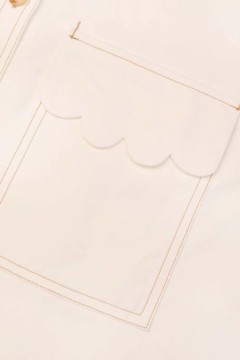 Close-up of a beige fabric with scalloped edge trim