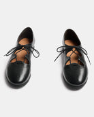 A pair of black leather lace-up shoes with a rounded toe and decorative cutout details, shown from a top-down view on a light gray background.