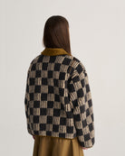 Person wearing a checkered jacket with a plain background