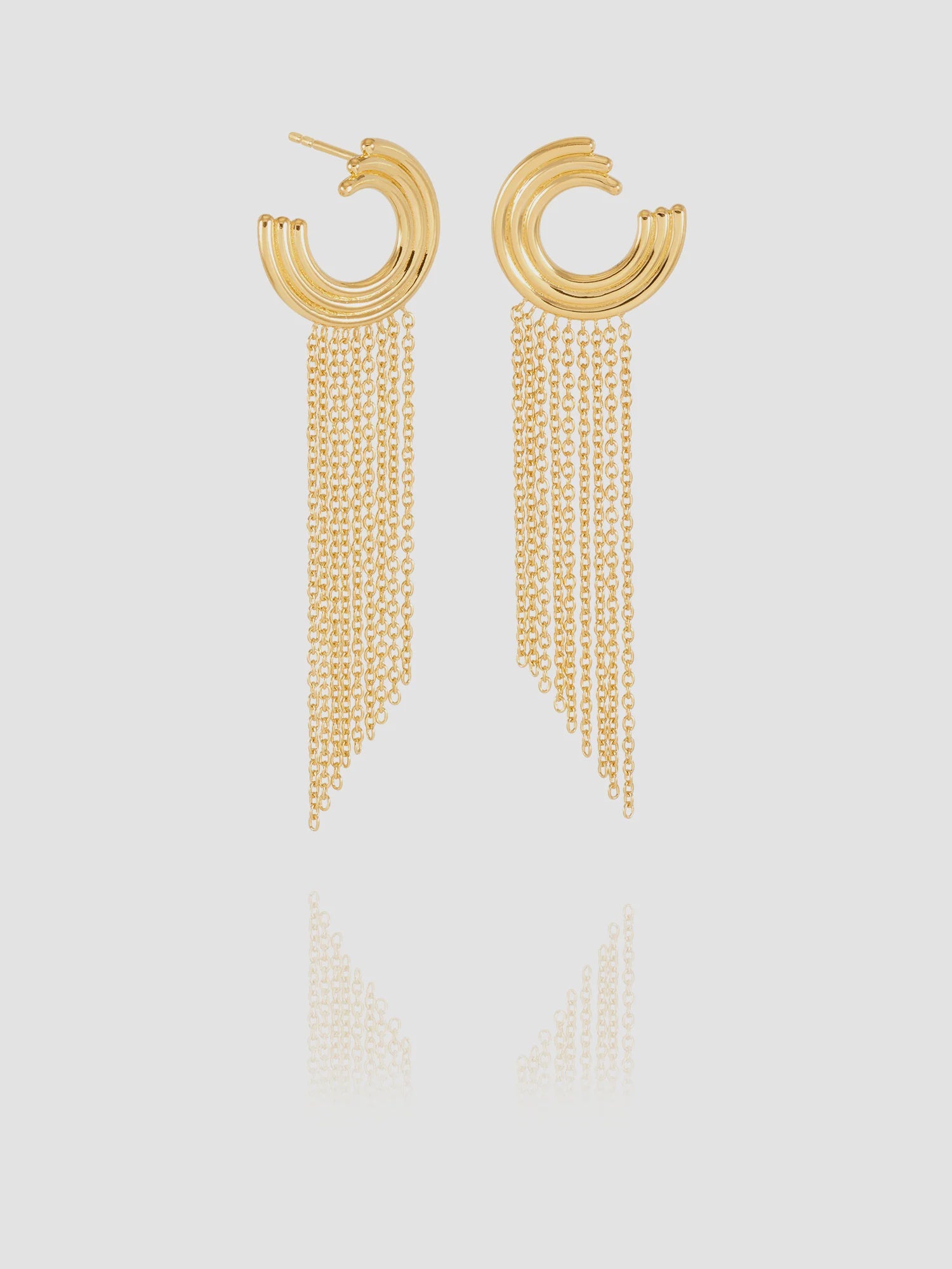 Gold hoop earrings with chain tassels on a light gray background