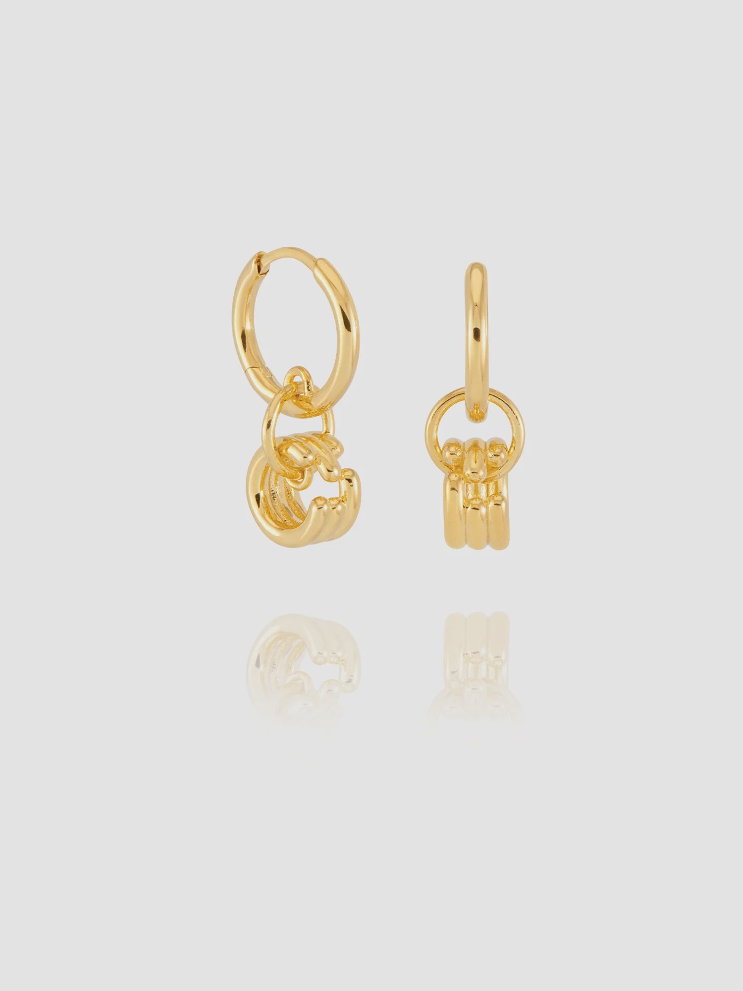 Gold hoop earrings with key-shaped charms on a light gray background