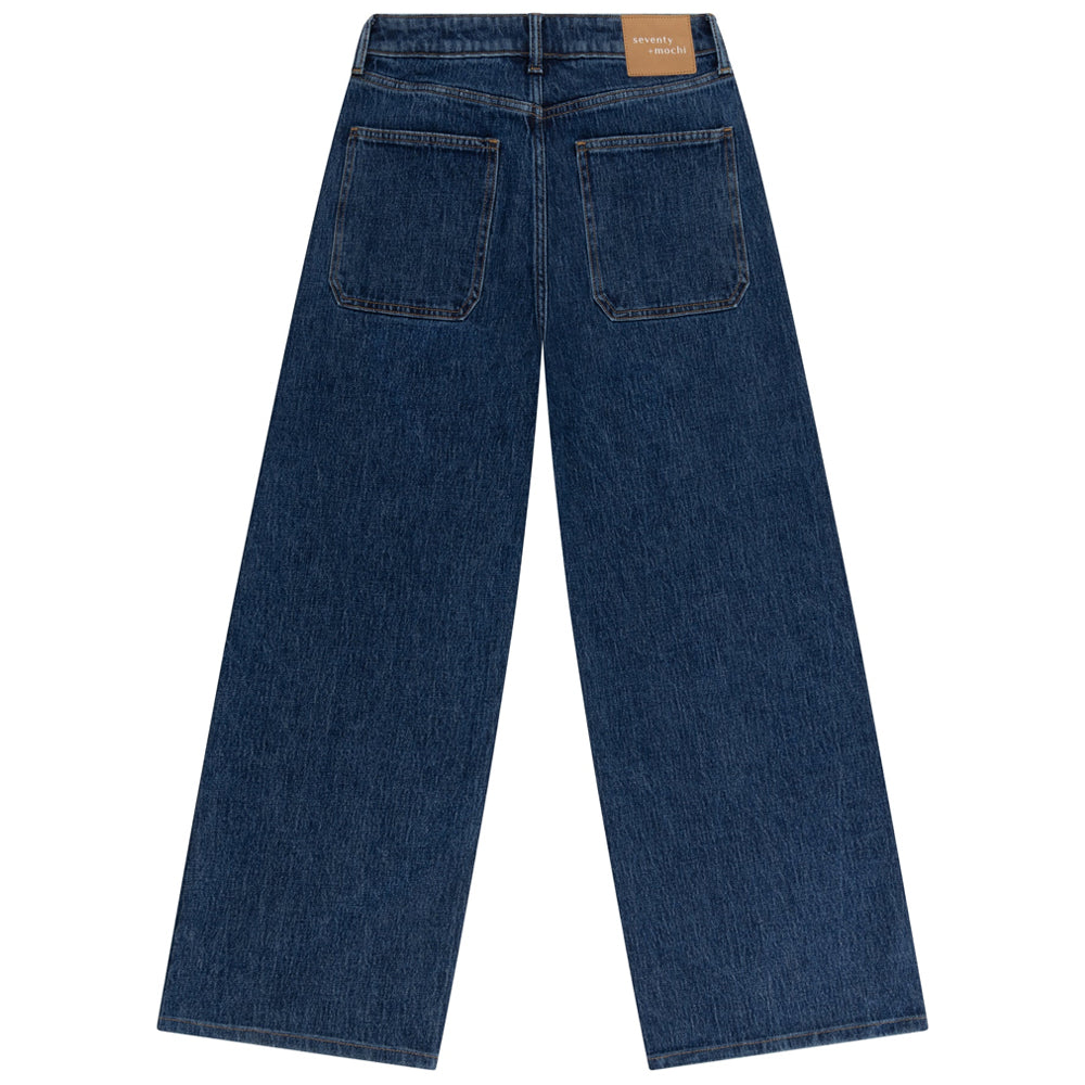 Back view of a pair of blue jeans on a white background