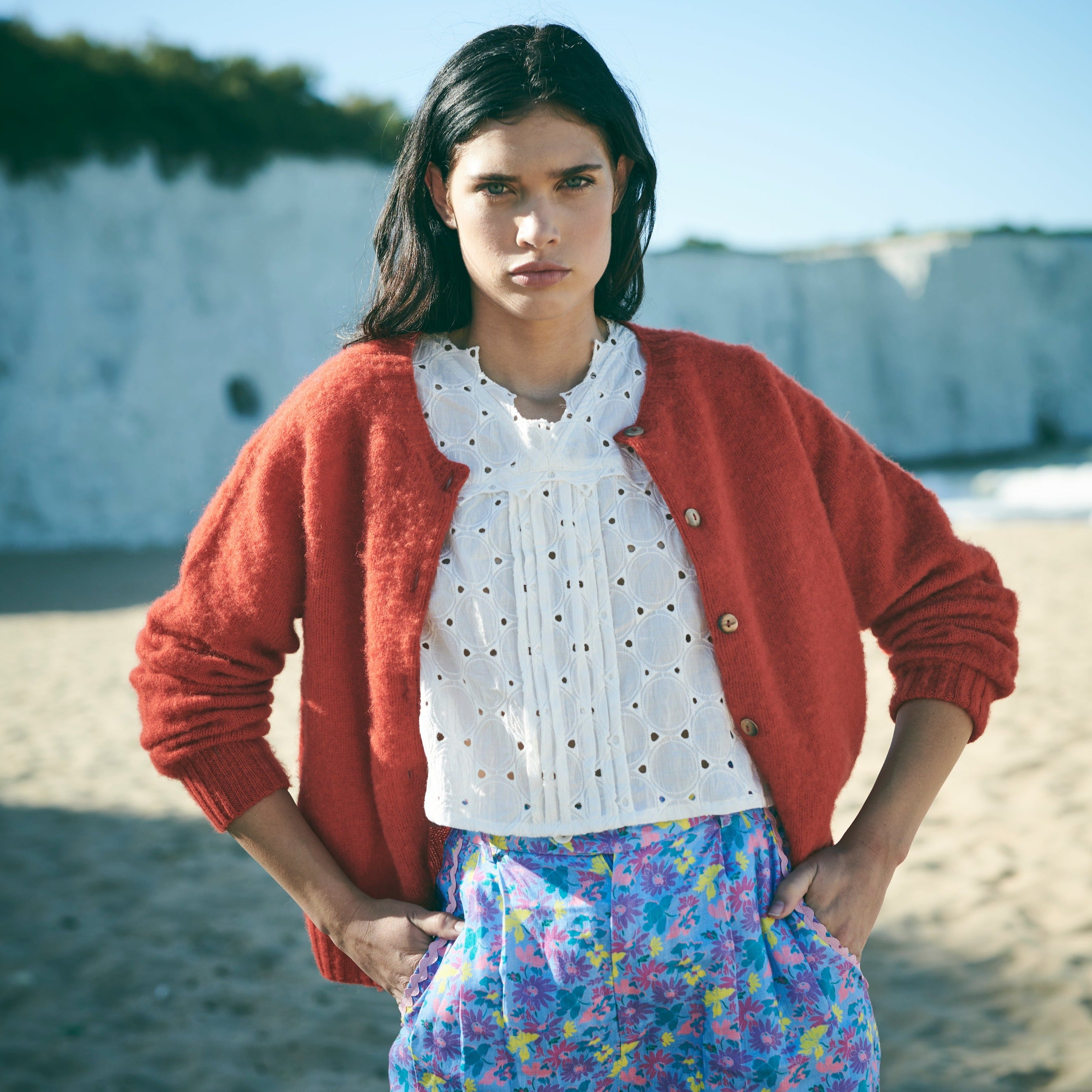 Red cardigan with button details on a white background